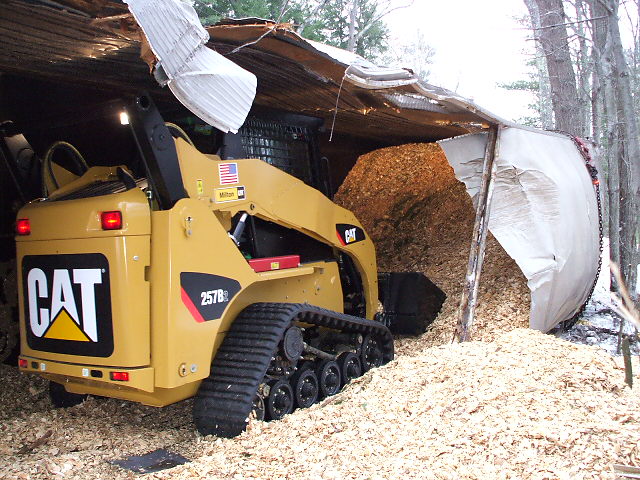 truck on its side in a pile of wood chips
