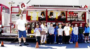 group of kids in front of a firetruck