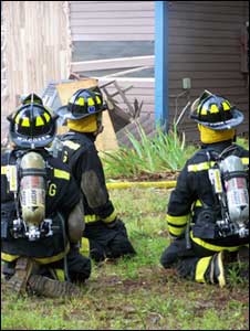 firemen outside a burning barn