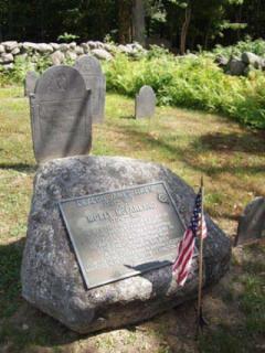 rock with a plaque in a cemetery