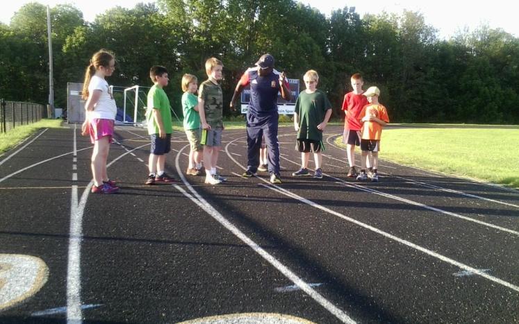 children and adults on running track